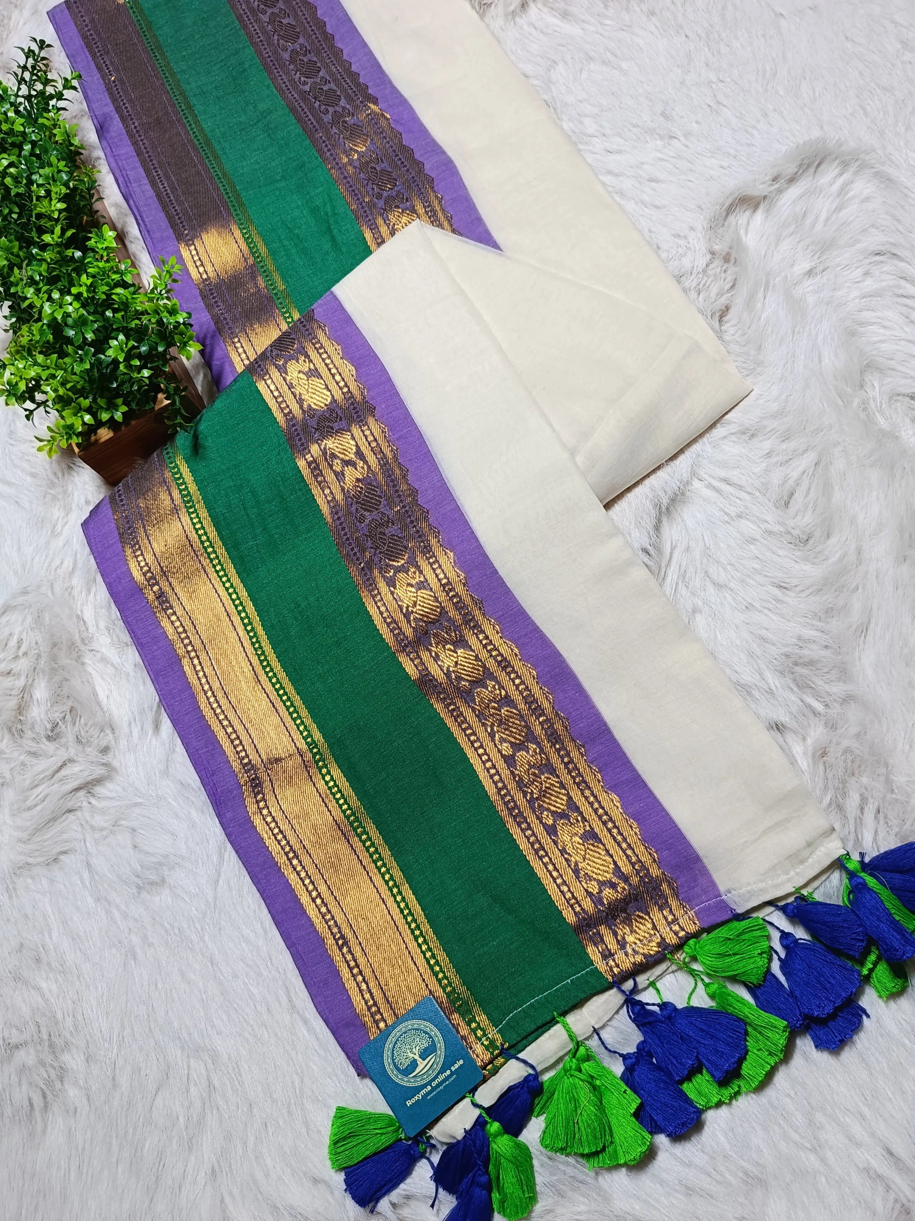 Decorative table runner with green, purple, and gold patterns on a white surface.